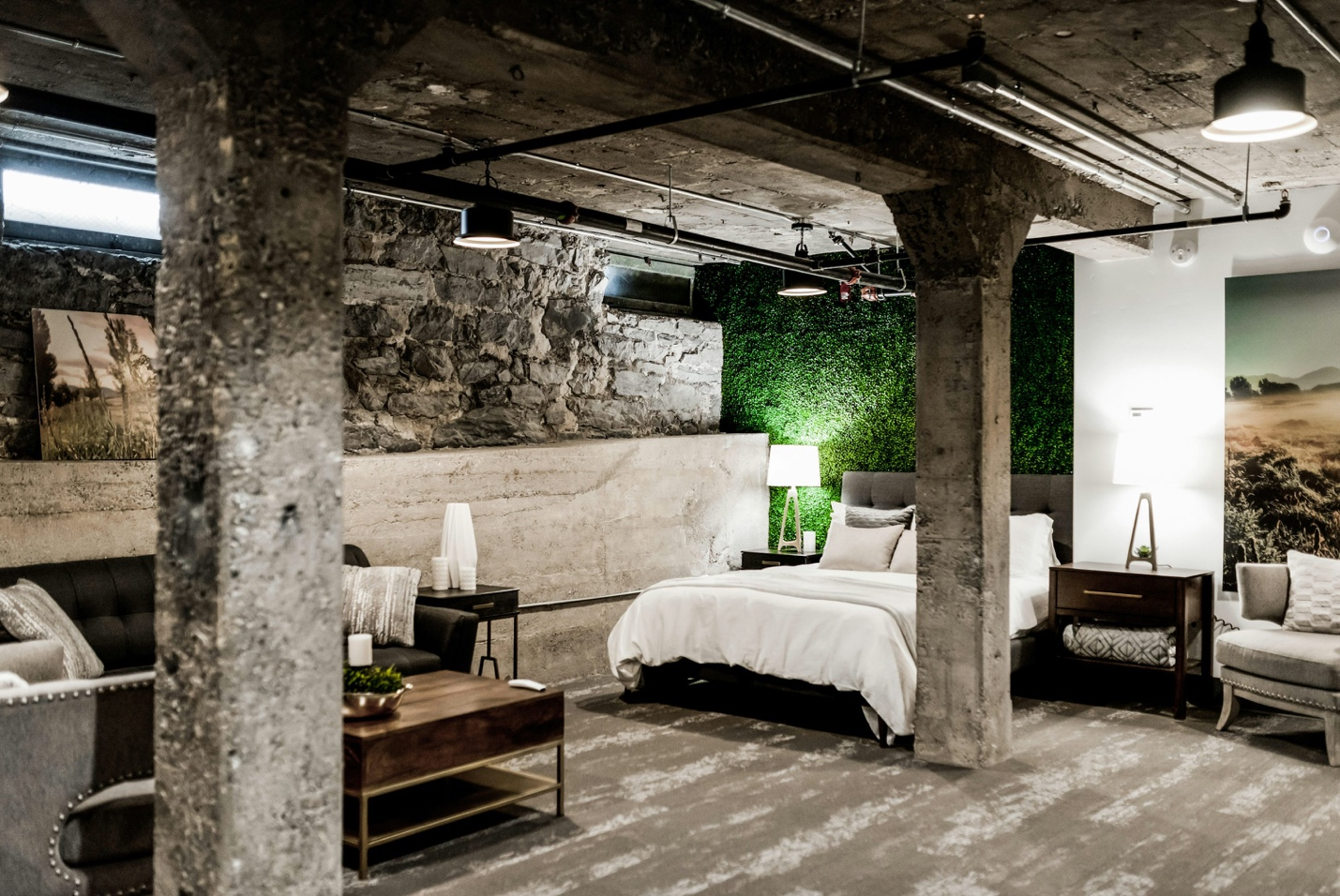 A cozy bedroom with exposed brick walls and warm lighting, repurposed from a basement space.